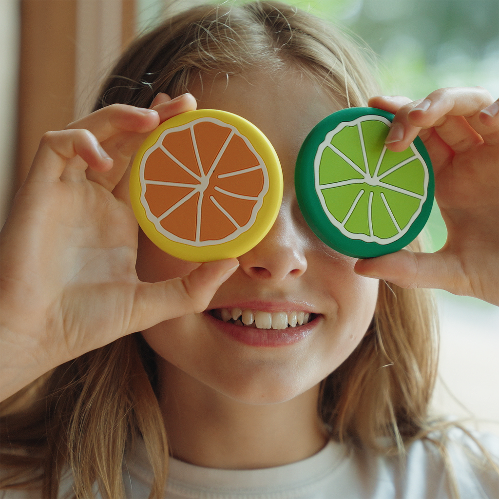 Pet crate accessories crate charms held by child front view Crate Charms brand colorful snap-on decorations